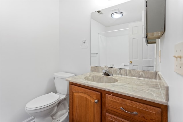 bathroom with a shower, vanity, and toilet