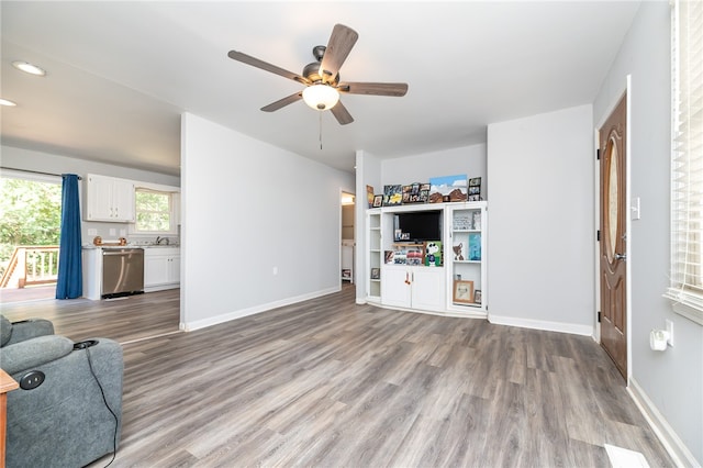 living room featuring light hardwood / wood-style floors, ceiling fan, and sink