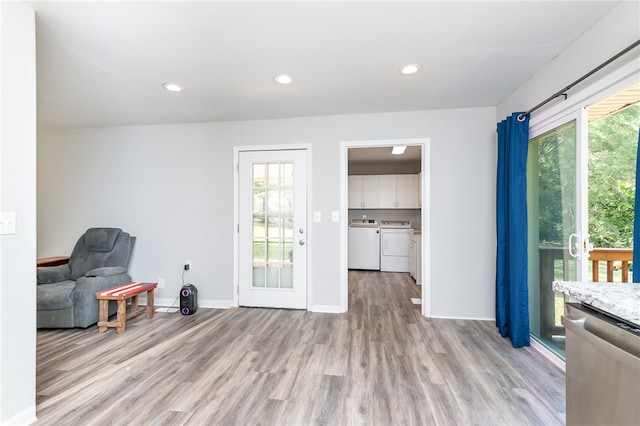 sitting room with washer and clothes dryer, light hardwood / wood-style floors, and a wealth of natural light