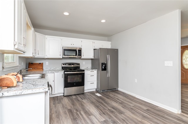 kitchen featuring white cabinetry, appliances with stainless steel finishes, hardwood / wood-style floors, and sink