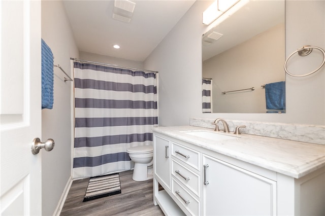 bathroom with a shower with curtain, hardwood / wood-style flooring, vanity, and toilet