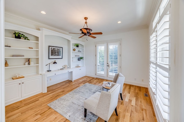 living area with light wood-type flooring, ceiling fan, french doors, and crown molding