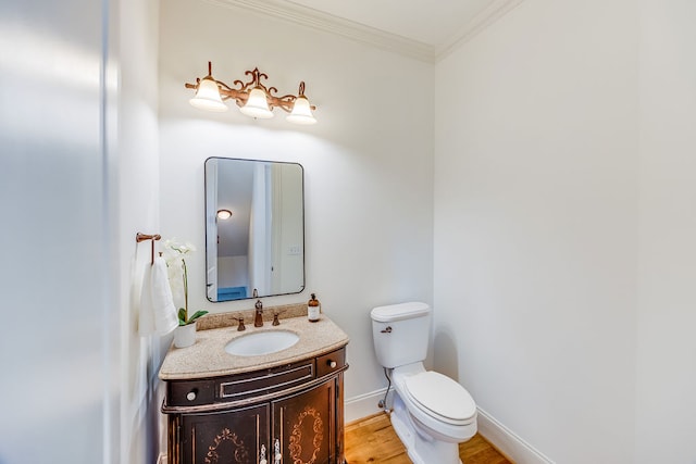 bathroom with wood-type flooring, ornamental molding, vanity, and toilet