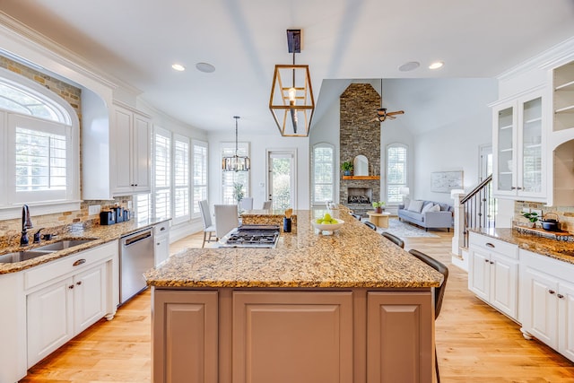 kitchen featuring stainless steel appliances, sink, white cabinetry, and a kitchen island