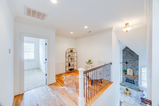 corridor featuring ornamental molding and light hardwood / wood-style floors