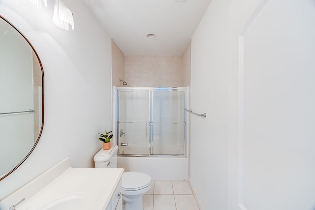 full bathroom featuring tile patterned floors, combined bath / shower with glass door, vanity, and toilet