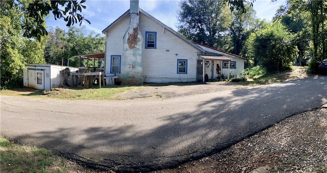 view of front of property featuring a shed