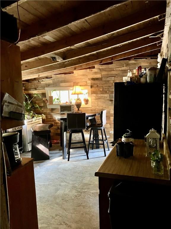 interior space with wood walls, wooden ceiling, and beam ceiling