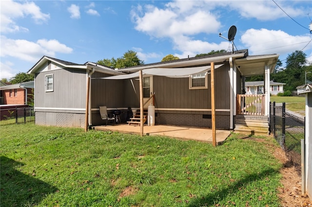 rear view of property with a lawn and a patio