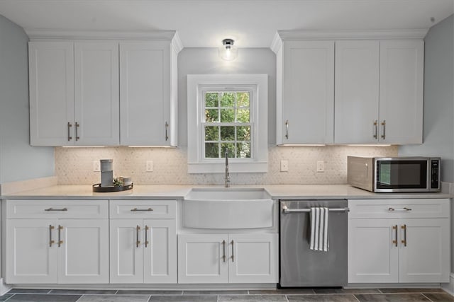 kitchen featuring sink, appliances with stainless steel finishes, white cabinets, and tasteful backsplash