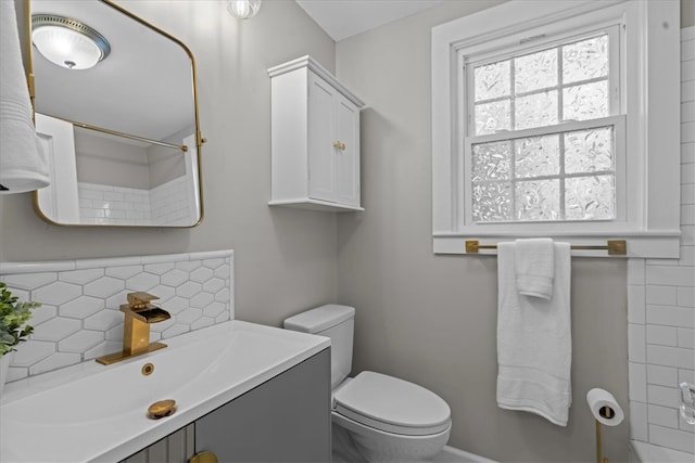 bathroom with vanity, a shower, toilet, and tasteful backsplash