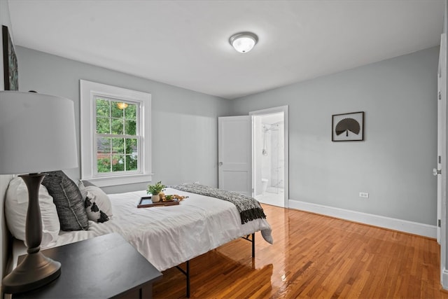 bedroom featuring ensuite bathroom and hardwood / wood-style flooring