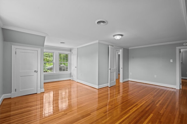 empty room with crown molding and hardwood / wood-style flooring