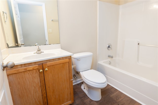 full bathroom featuring  shower combination, vanity, hardwood / wood-style flooring, and toilet