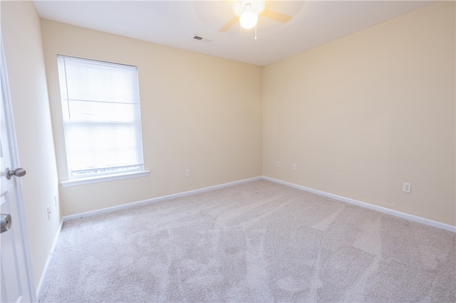 spare room with ceiling fan and light colored carpet