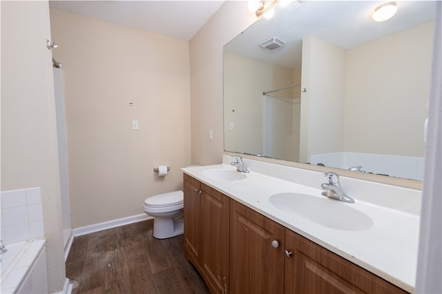 bathroom featuring a bath, toilet, hardwood / wood-style flooring, and vanity