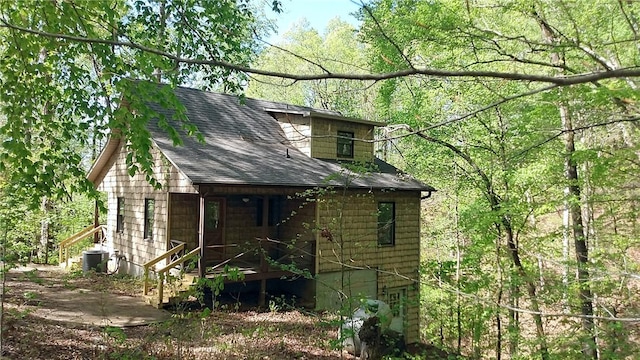 157 Deerwood Dr, Westminster, SC 29693 - view of side of home with covered porch, a forest view, central AC unit, and roof with shingles