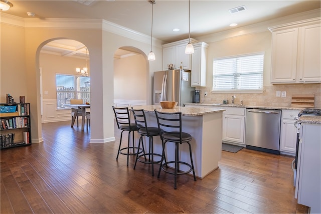 kitchen featuring appliances with stainless steel finishes, dark hardwood / wood-style floors, white cabinetry, and a center island