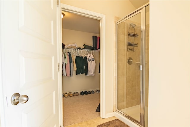 bathroom with walk in shower and tile patterned flooring