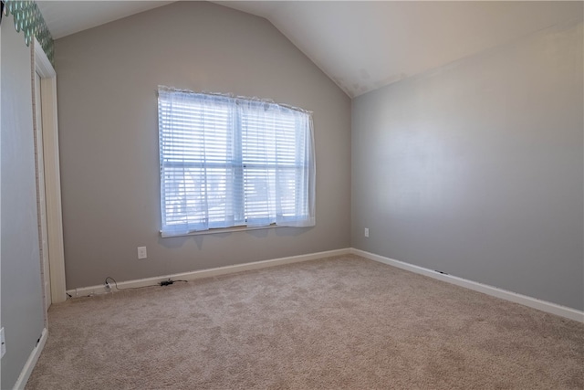 carpeted empty room with lofted ceiling