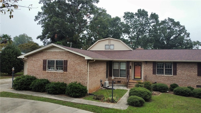 view of front facade featuring a front lawn and central air condition unit