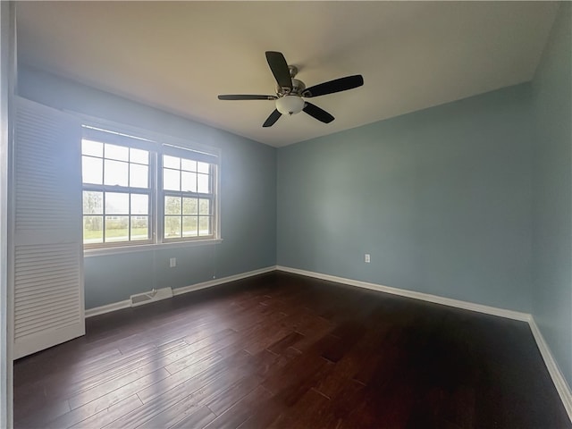 unfurnished room with ceiling fan and dark wood-type flooring