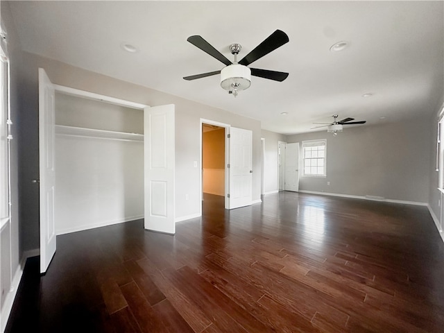 unfurnished bedroom with ceiling fan, a closet, and dark hardwood / wood-style flooring