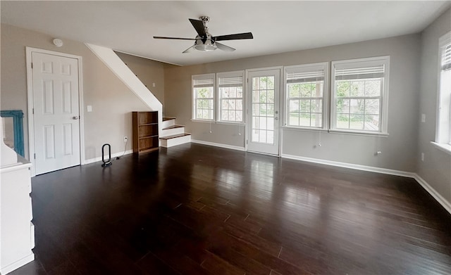 unfurnished living room with ceiling fan and dark wood-type flooring