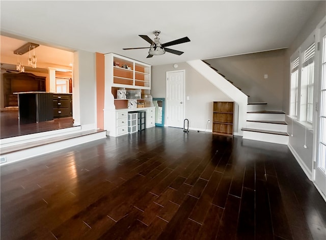 unfurnished living room with dark hardwood / wood-style floors and ceiling fan