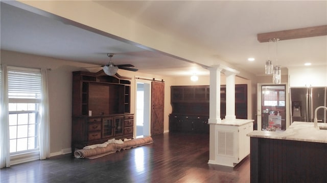 kitchen with ceiling fan, an island with sink, decorative light fixtures, stainless steel fridge with ice dispenser, and dark hardwood / wood-style floors