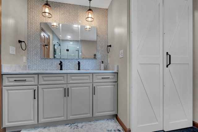 bathroom with decorative backsplash, a shower with shower door, and vanity