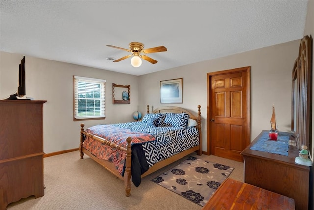 bedroom featuring a textured ceiling, ceiling fan, and light colored carpet