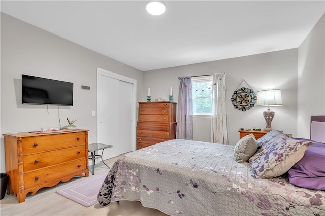 bedroom with light hardwood / wood-style flooring and a closet