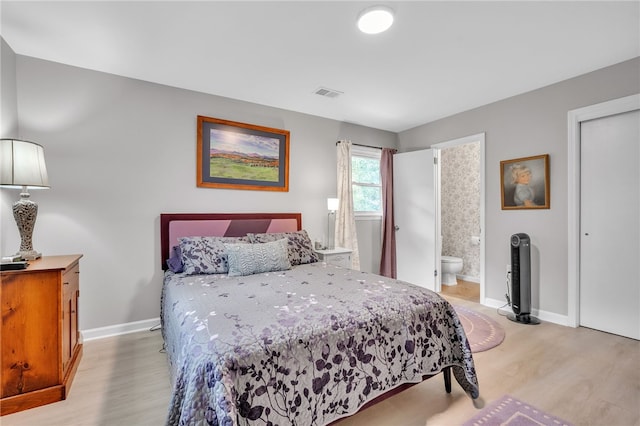 bedroom with light wood-type flooring and ensuite bath