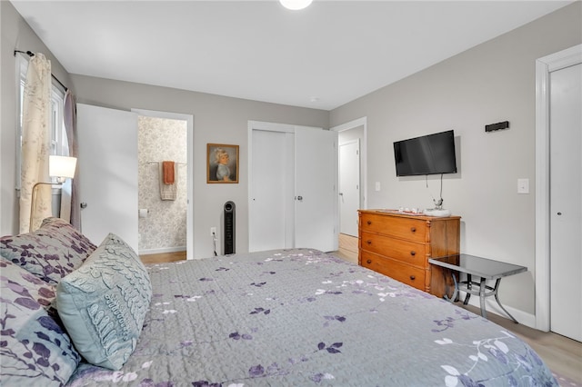 bedroom with connected bathroom and hardwood / wood-style floors