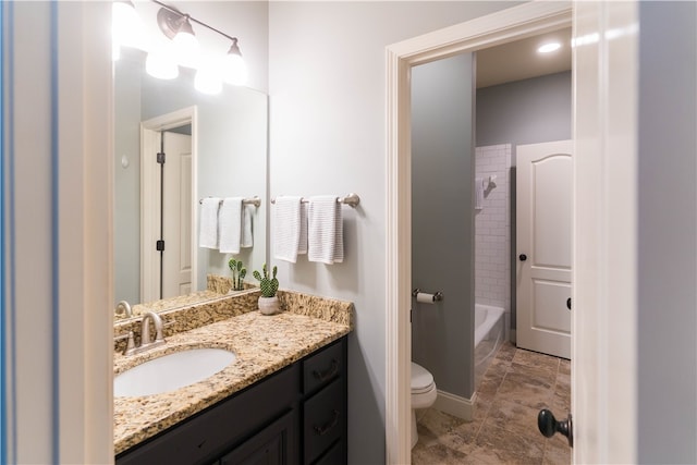 full bathroom with tiled shower / bath, vanity, and toilet