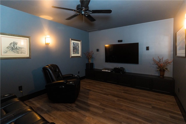 home theater room with ceiling fan and dark wood-type flooring