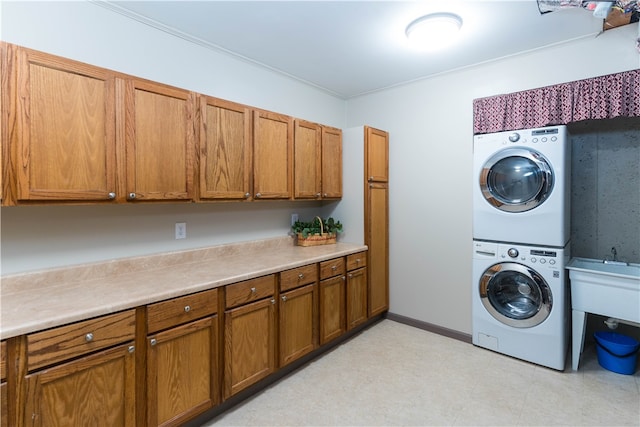 laundry area featuring stacked washer and dryer and cabinets