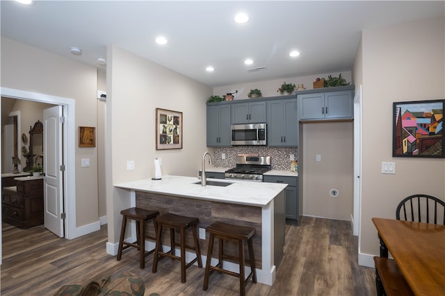 kitchen featuring kitchen peninsula, sink, tasteful backsplash, stainless steel appliances, and dark hardwood / wood-style floors