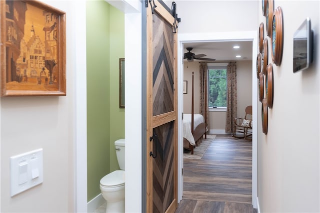 bathroom with wood-type flooring, ceiling fan, and toilet