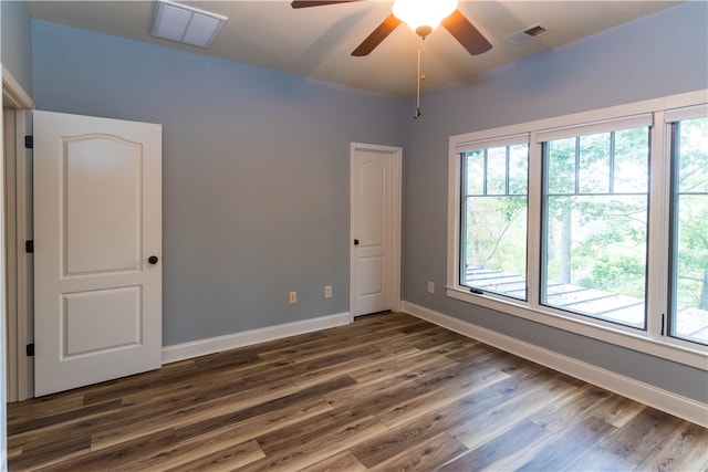 spare room with ceiling fan, plenty of natural light, and dark hardwood / wood-style flooring