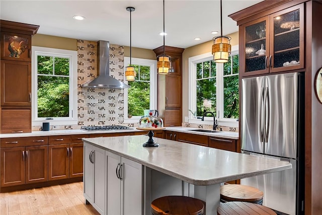 328 Grand Overlook Dr, Seneca, SC 29678 - kitchen featuring stainless steel appliances, wall chimney exhaust hood, light countertops, a kitchen bar, and a sink