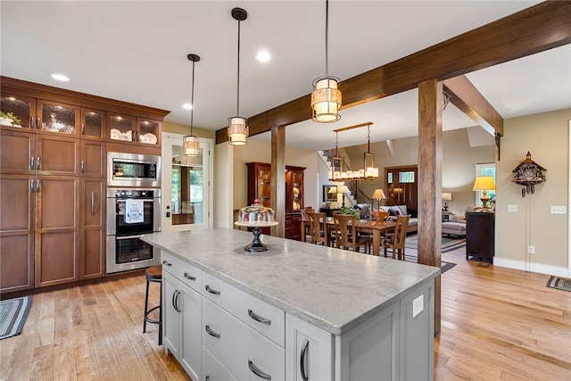 328 Grand Overlook Dr, Seneca, SC 29678 - kitchen featuring appliances with stainless steel finishes, light wood-type flooring, a center island, glass insert cabinets, and decorative light fixtures