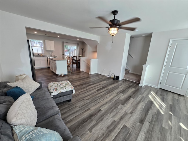 living room with ceiling fan and dark wood-type flooring