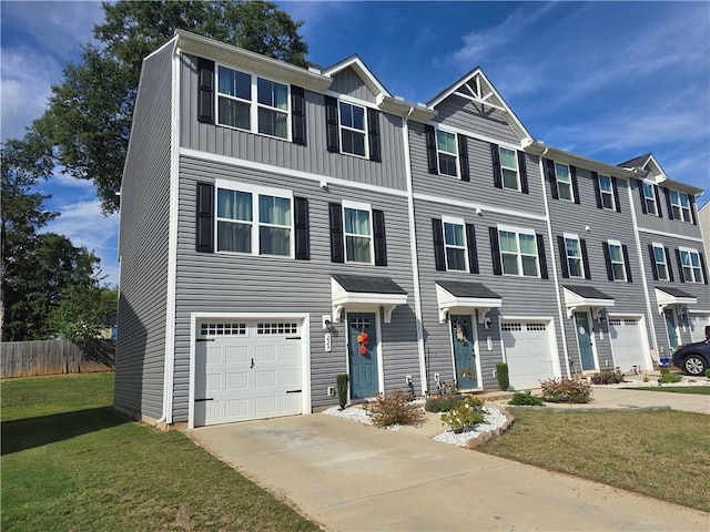 townhome / multi-family property with a front yard and a garage