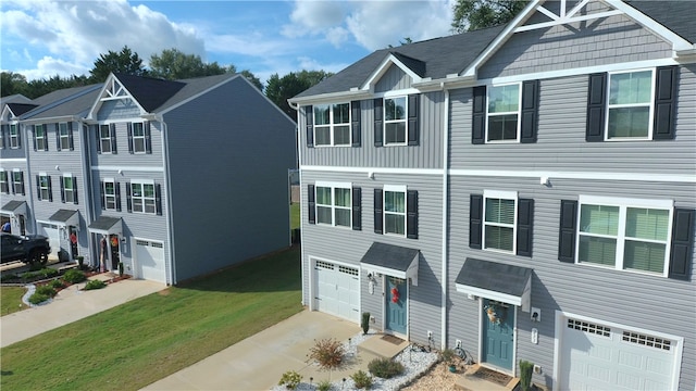 multi unit property featuring a garage and a front lawn