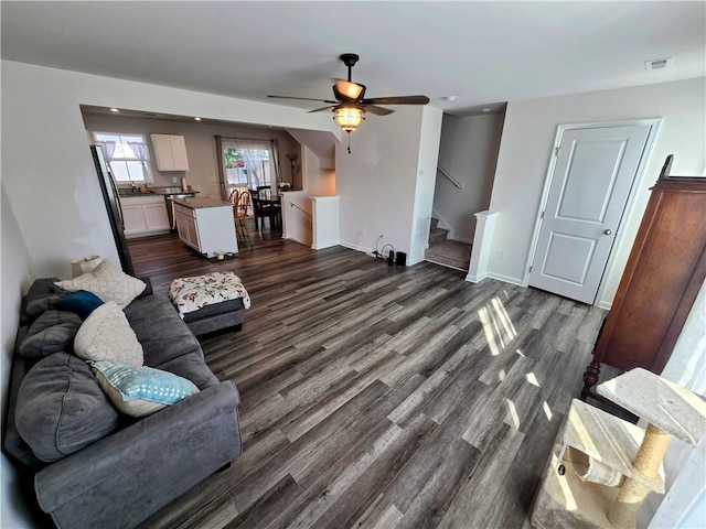 living room with dark hardwood / wood-style flooring, ceiling fan, and sink