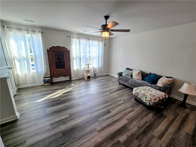 living room with ceiling fan, dark wood-type flooring, and a healthy amount of sunlight