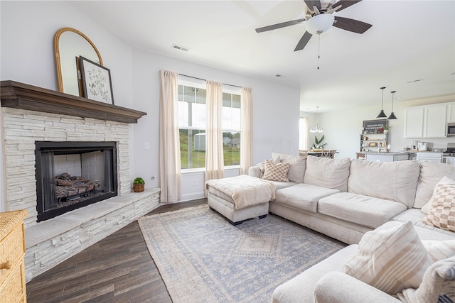 living room featuring ceiling fan, a fireplace, and light hardwood / wood-style floors