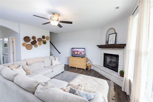 living room with ceiling fan, a fireplace, and dark hardwood / wood-style flooring